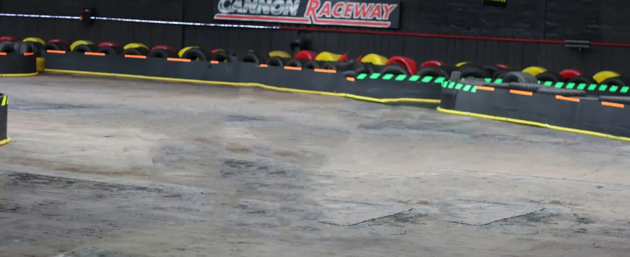 Empty go-kart racing track with coloured tyres and bumpers lining the course.