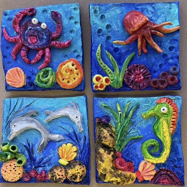 Four colourful painted tiles featuring textured undersea creatures and plants in blues, reds and greens.