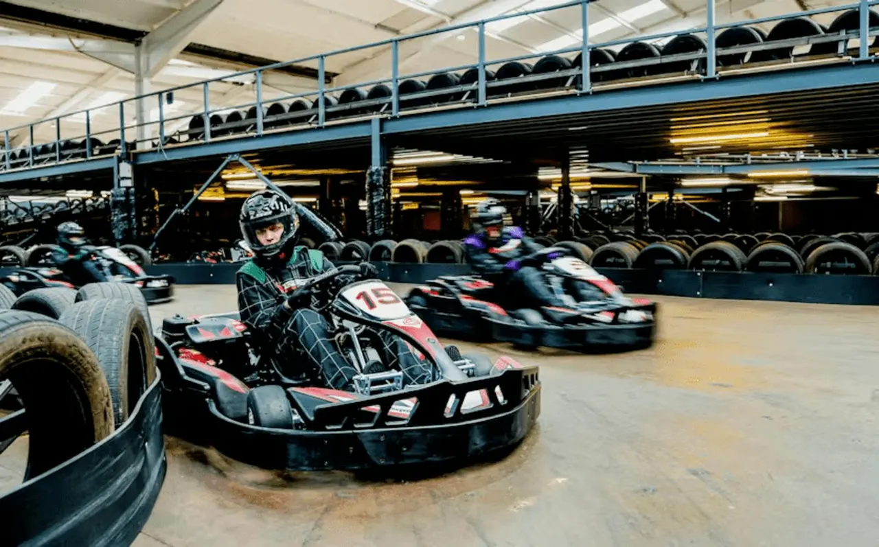 Red petrol go-karts racing on indoor TeamSport circuit