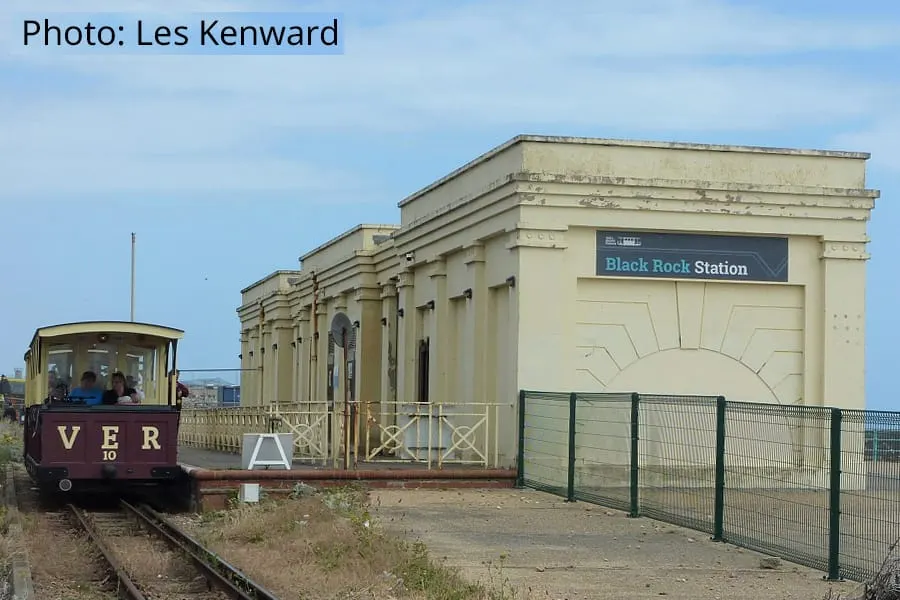 A vintage tram and restored railway station building at Black Rock Station on a clear day.