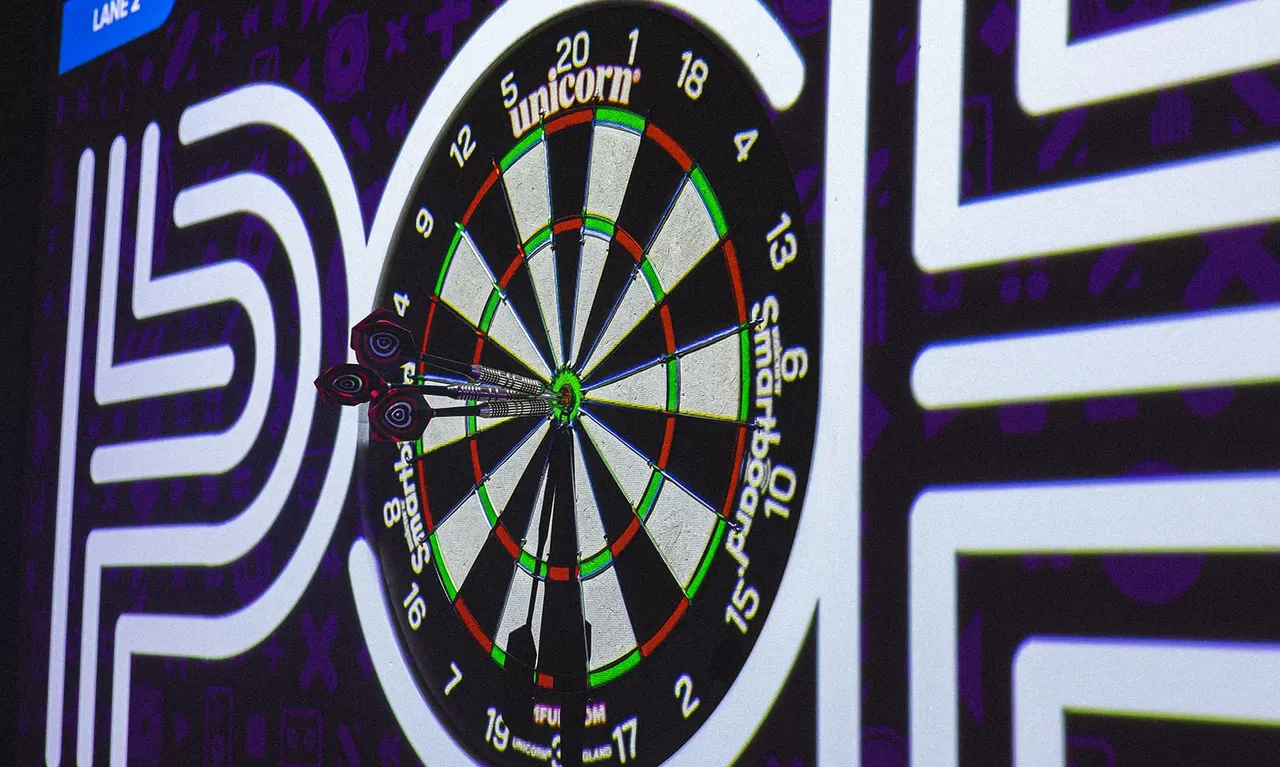 Electronic dartboard with three darts in the board, surrounded by neon signage in purple and white lighting.