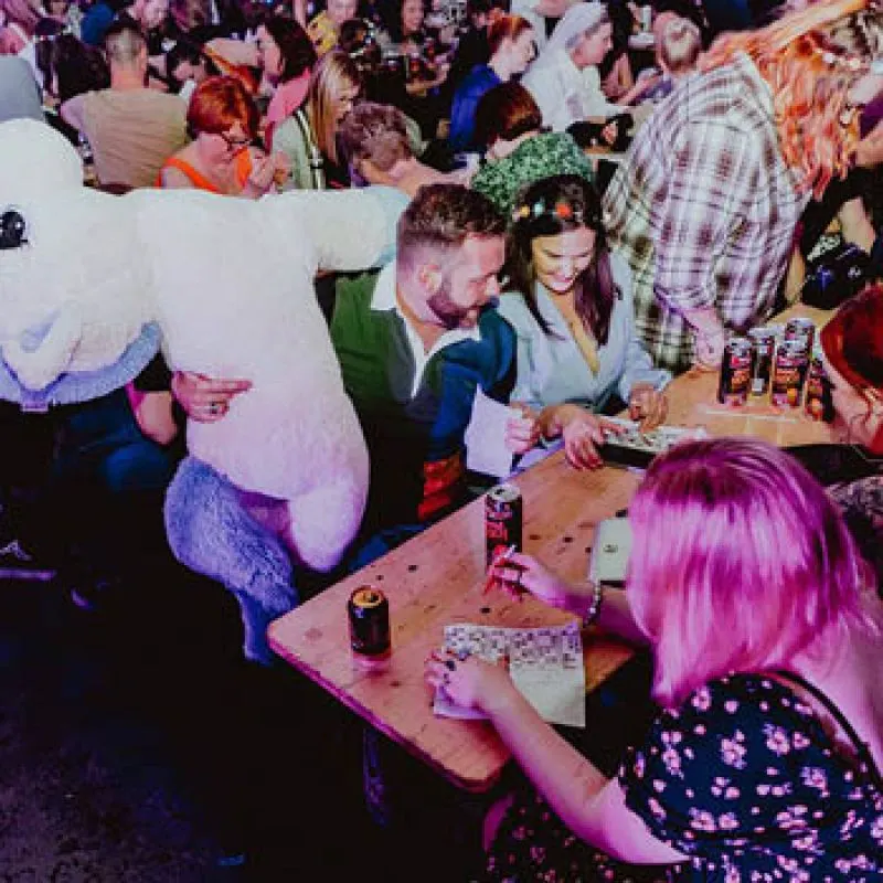 Guests socialise and drink at a lively indoor event with people gathered around tables at Salisbury City Hall.
