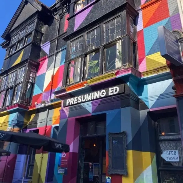 Historic building facade decorated with vibrant multicoloured geometric panels in red, blue, yellow and pink.