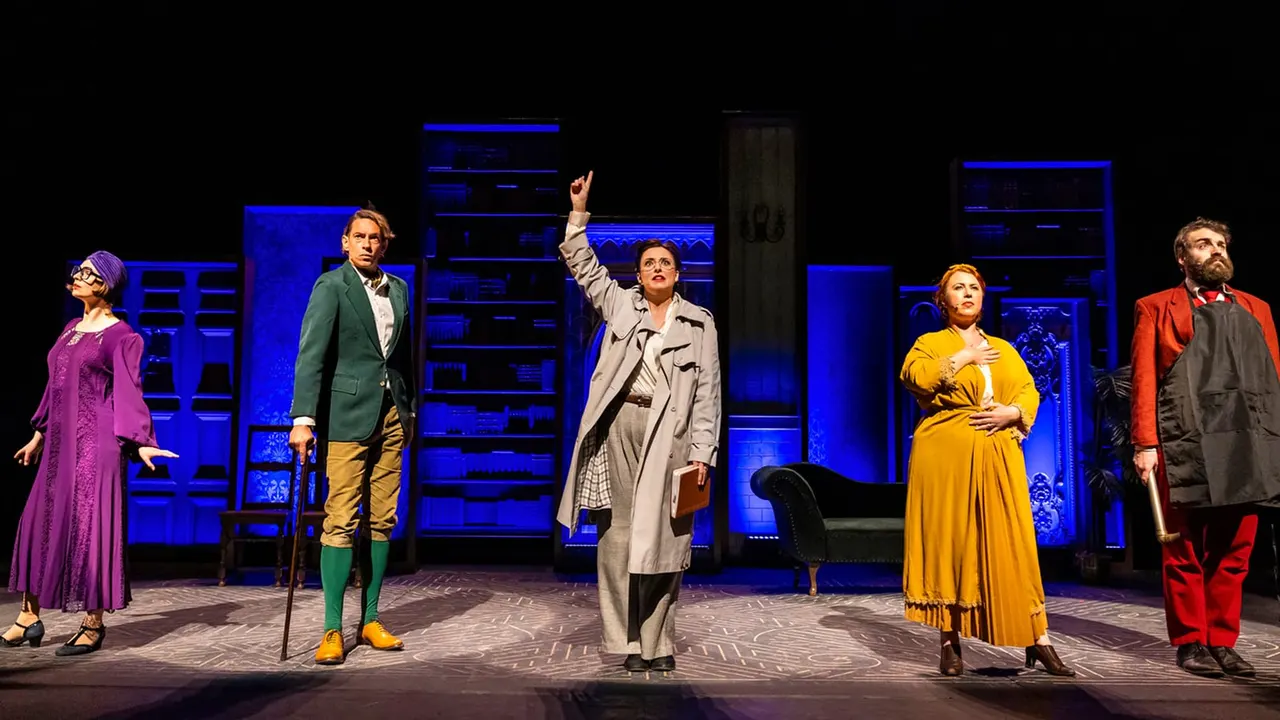 Five actors perform a scene on stage with blue-lit set pieces behind them.