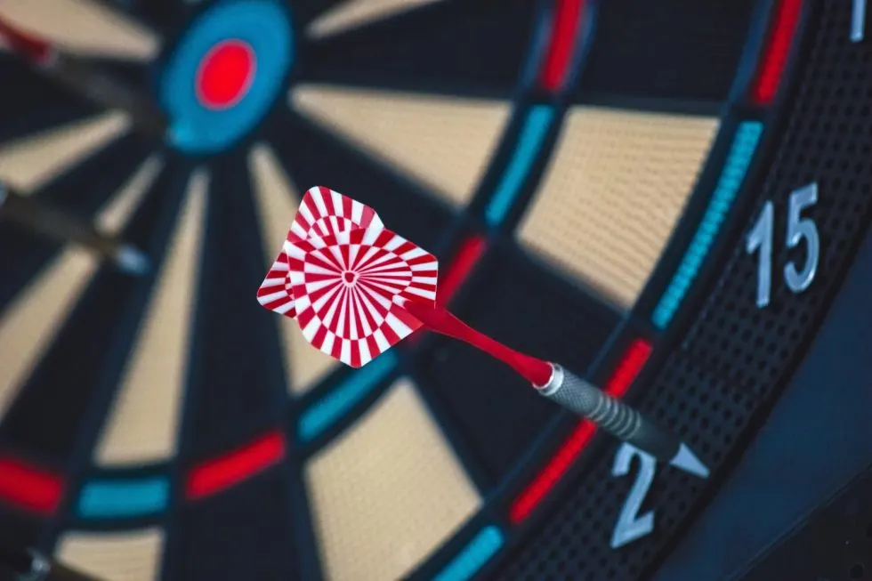 A red and white striped dart positioned on a dartboard with numbered segments.