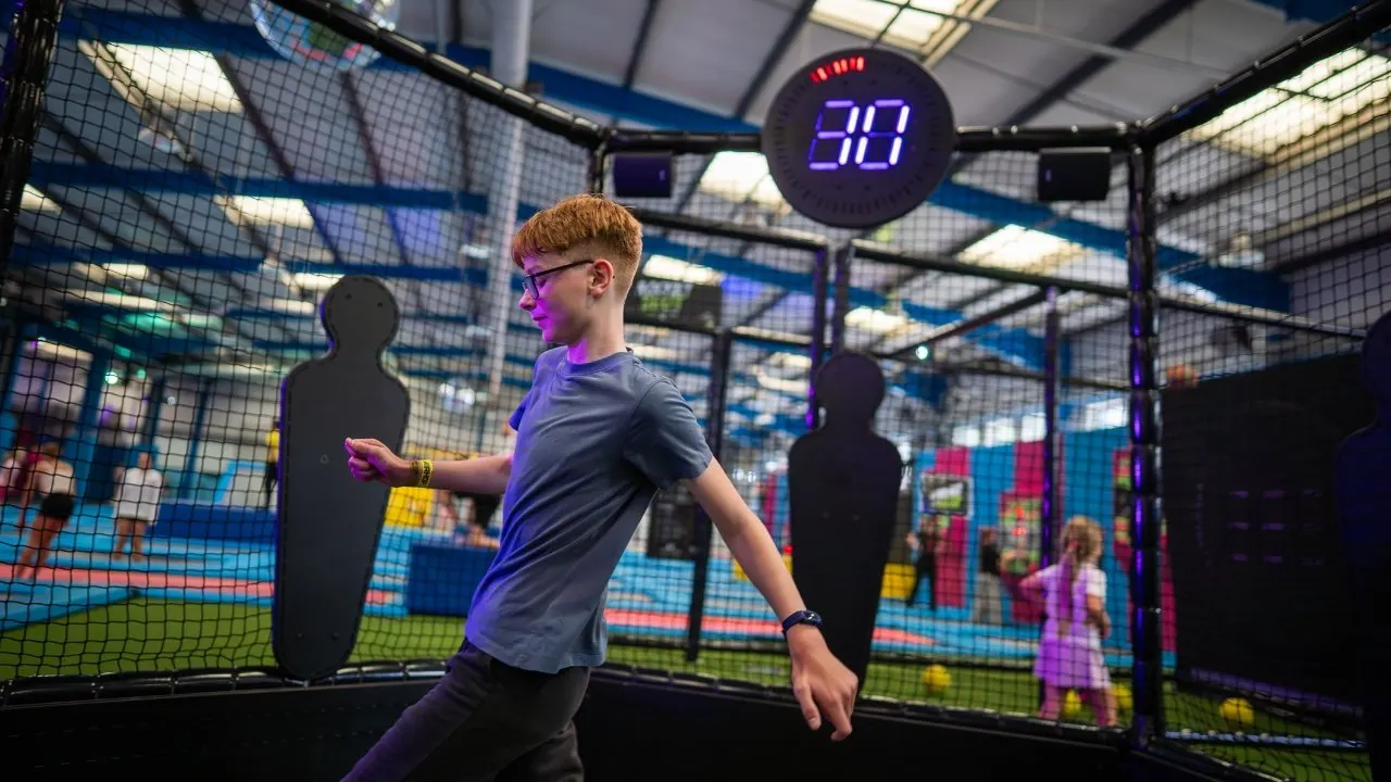 Interactive cage with trampoline court behind at AirHop Warwick
