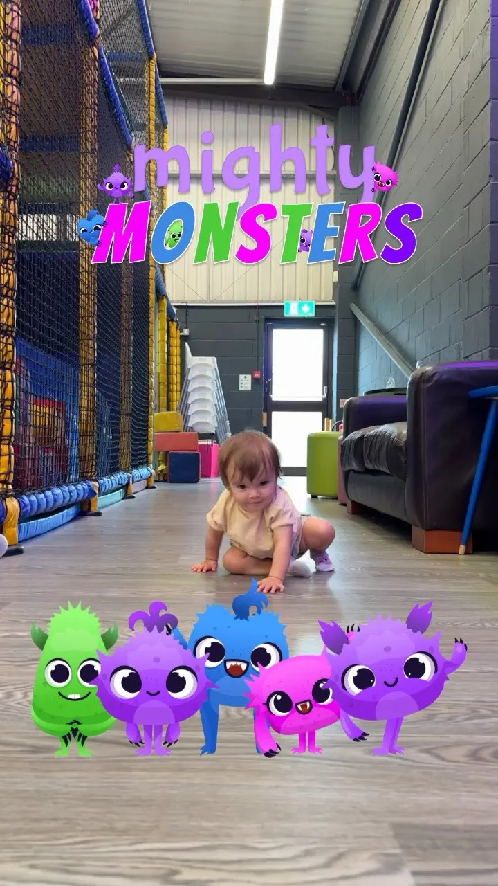 Toddler crawling on the floor near the soft-play frame and parent seating