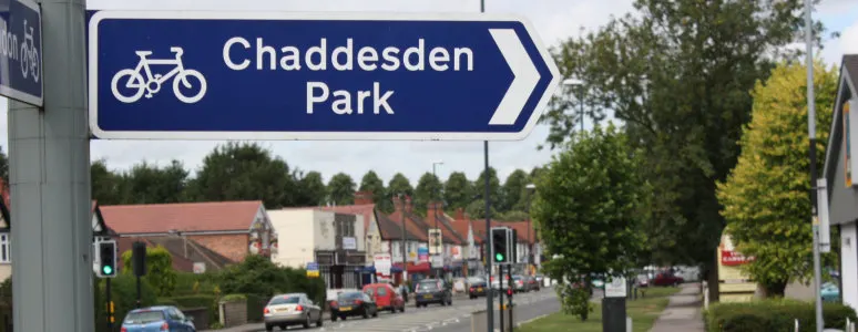 Directional road sign for Chaddesden Park with suburban street and buildings visible in background.