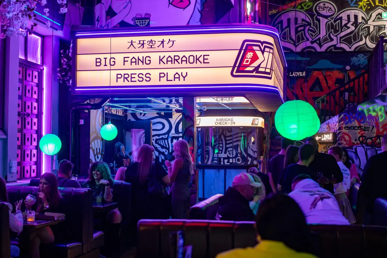 Big Fang Karaoke check-in desk with neon marquee and green lanterns at Golf Fang Nottingham