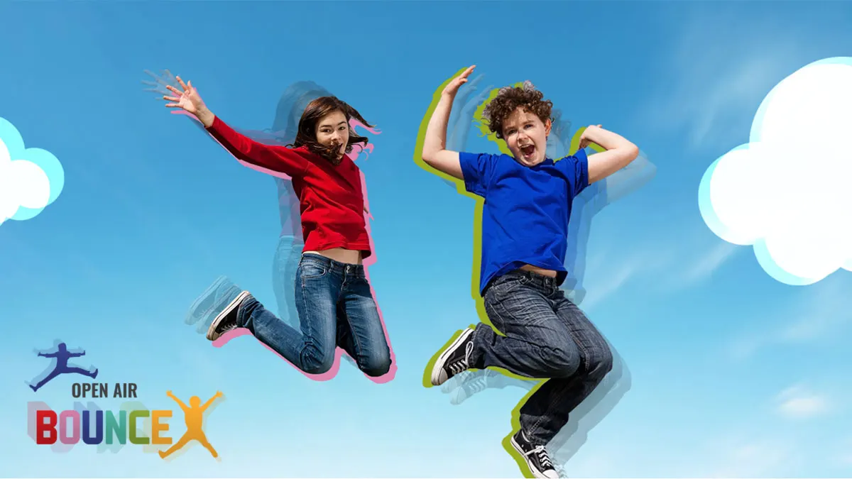 Two children jumping mid-air against a bright blue sky with white clouds and coloured auras around them.