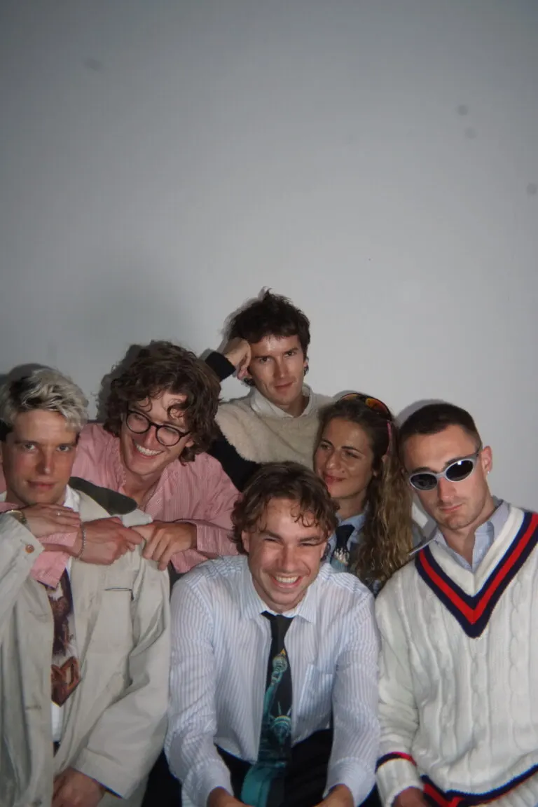 This is a designed graphic (a posed group portrait/promotional photo with styled clothing and studio lighting), so I should reply with:

GRAPHIC