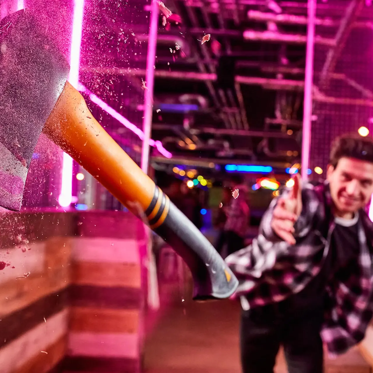 Confetti cannon firing in a neon-lit venue with people celebrating in the background.