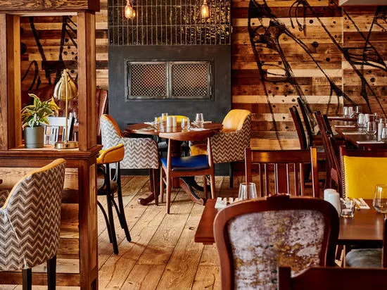 Stylish restaurant interior with wooden features, patterned chairs, and dining tables set for service.