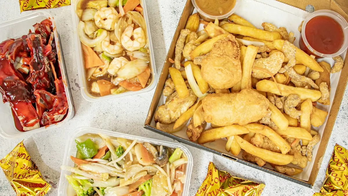 Takeaway food spread including battered fish and chips, sliced red peppers, stir-fried noodles with vegetables, and dipping sauces on a light surface.