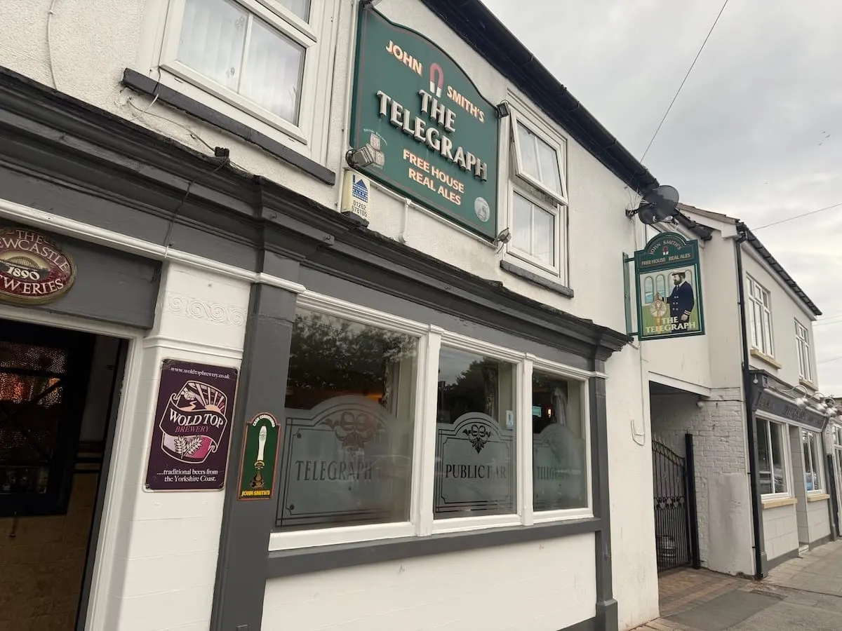 Exterior of The Telegraph public house, a traditional whitewashed pub with green signage on a street corner.