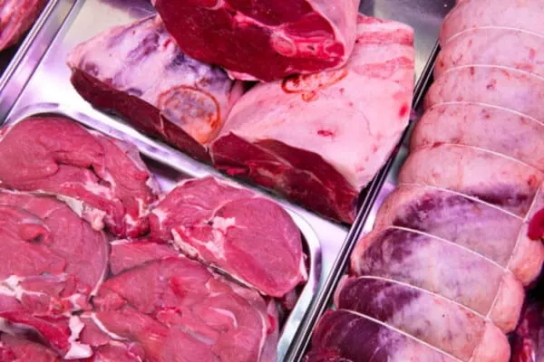 Raw meat cuts displayed in refrigerated butcher counter cases.