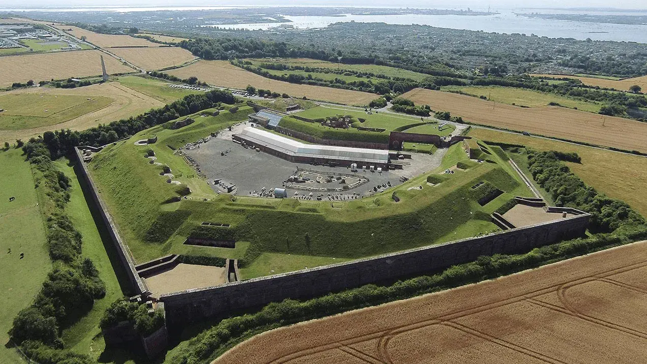 Aerial view of Fort Nelson, a historic star-shaped fortress with modern exhibition buildings, surrounded by defensive ramparts and green grounds in rural Hampshire.