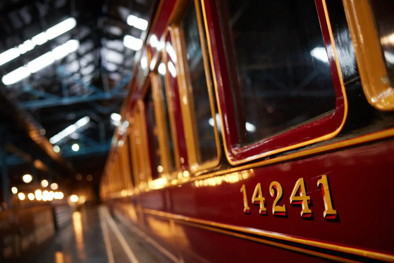 Close-up of a red and gold heritage steam locomotive numbered 14241 in a railway museum shed.