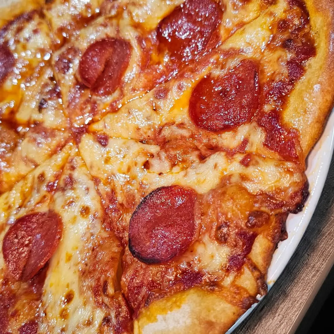 Close-up of pepperoni pizza with melted cheese and crispy crust.