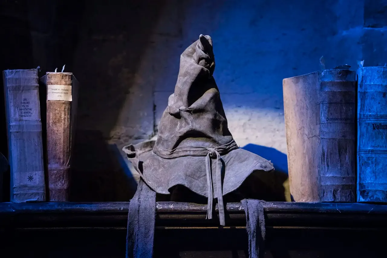 Sorting Hat from Harry Potter displayed on a pedestal surrounded by blue-lit books at the studio tour.