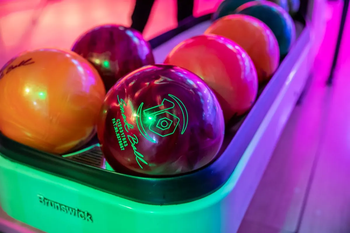 Multi-coloured bowling balls lined up in rack