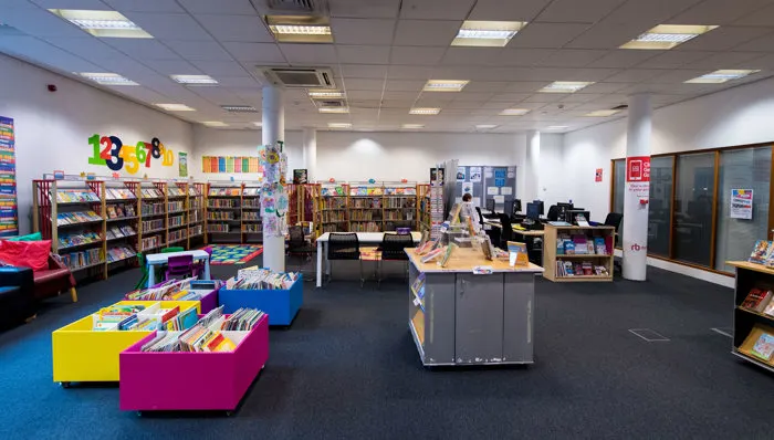 Bright, modern library interior with colourful seating and book displays for children and young people.