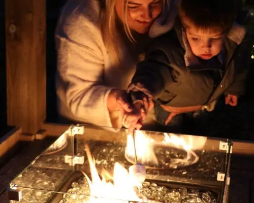 Woman and young child looking at illuminated animals in a touch tank or viewing enclosure.
