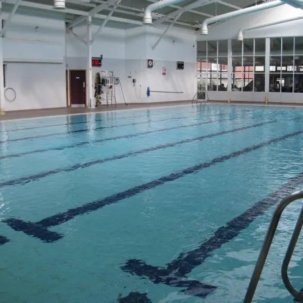 Empty indoor swimming pool with lane dividers in a modern leisure facility.