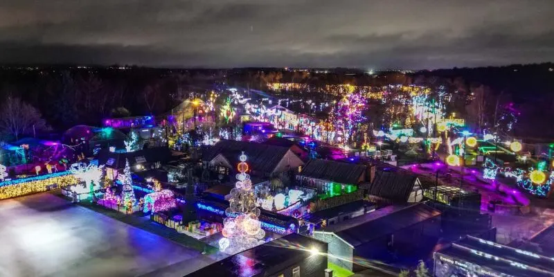 Aerial night view of an illuminated Christmas light display with colourful decorations across a winter leisure venue.