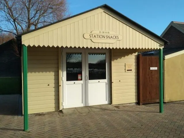 A small cream and green leisure facility building with "Station Snacks" signage and white entrance doors.