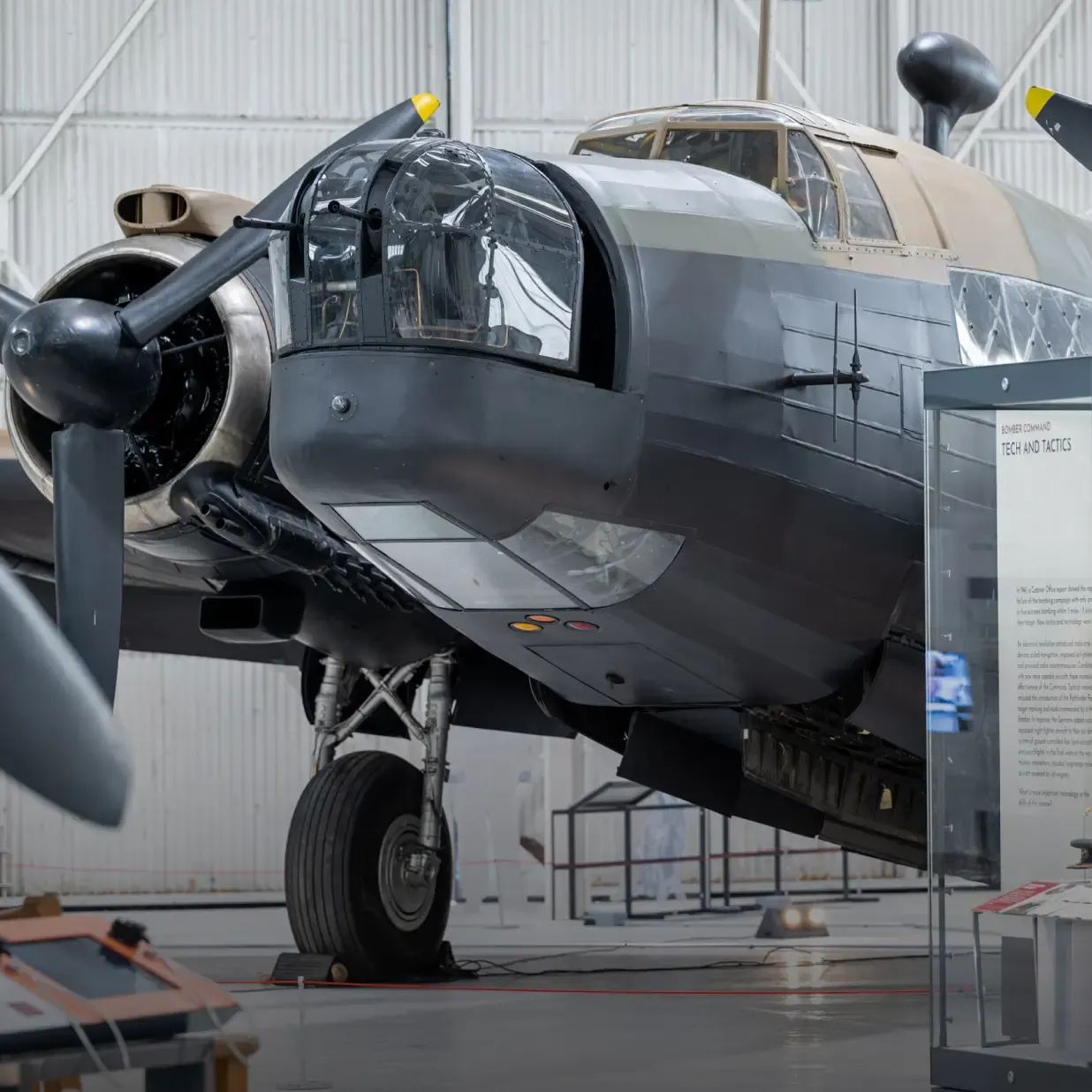 Historic military aircraft with open cockpit door displayed in museum hangar.
