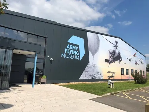 Modern building with Army Flying Museum signage and military helicopter imagery on exterior wall.