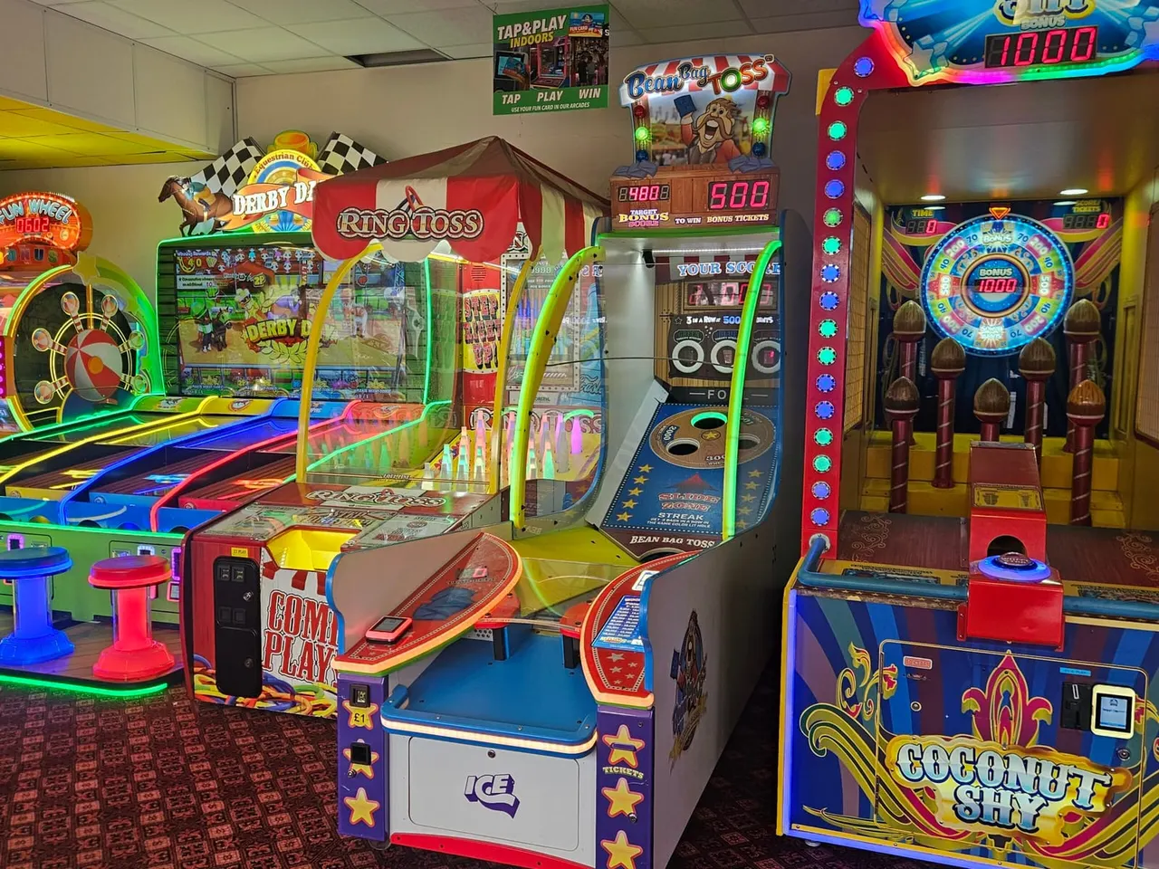 Indoor arcade with rows of colourful illuminated gaming and ticket redemption machines.