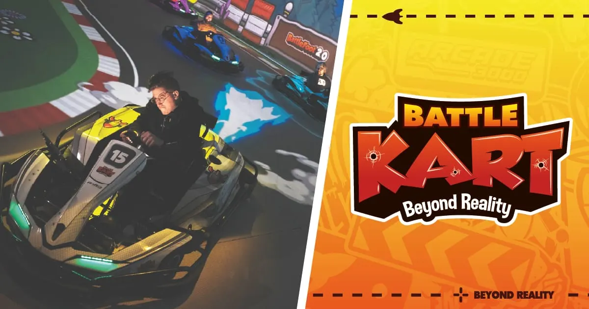 Person seated in a yellow and black racing kart on an indoor track with other karts visible in the background.