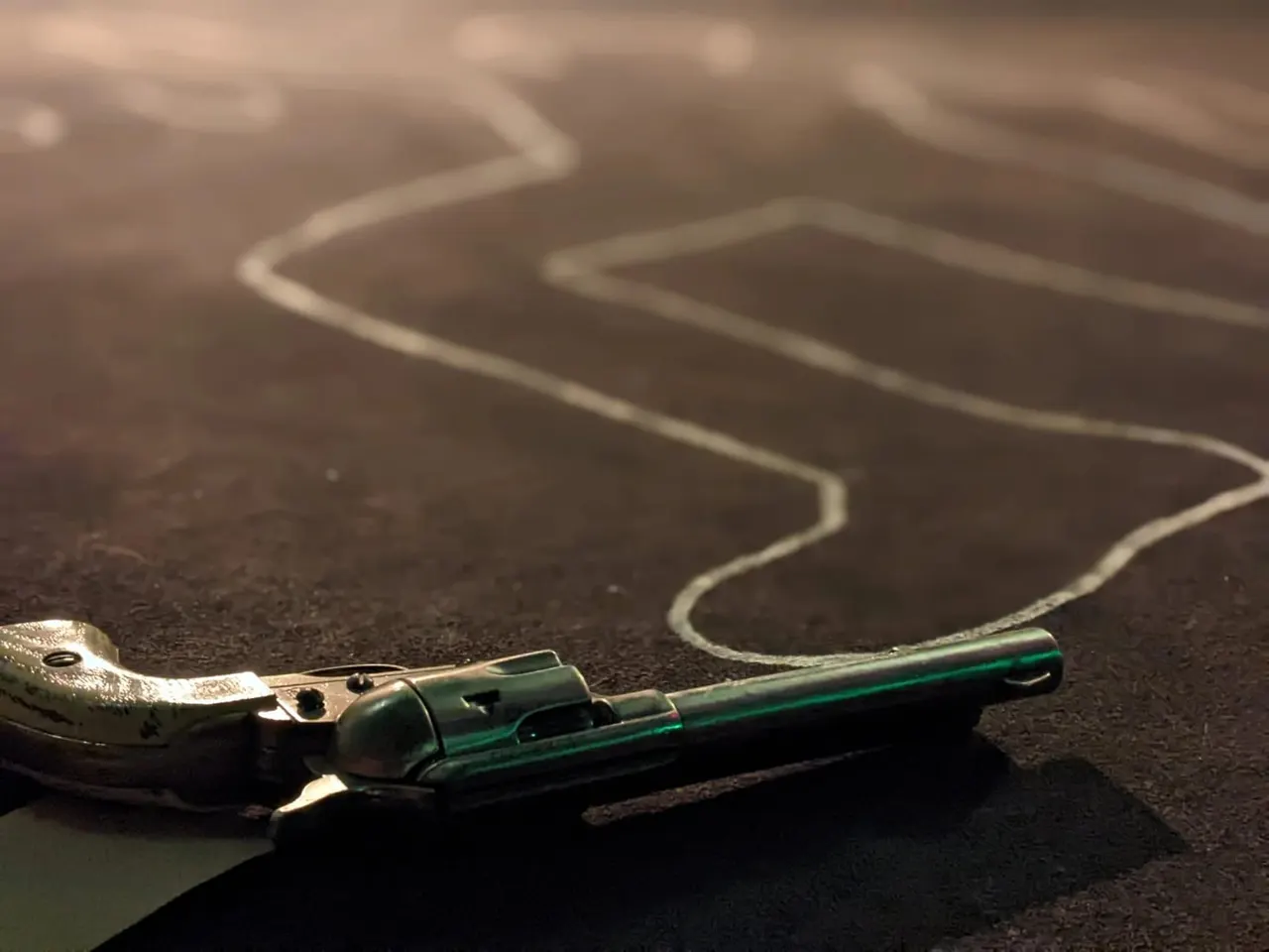Close-up of a whistle and rope on dark ground with white chalk markings.