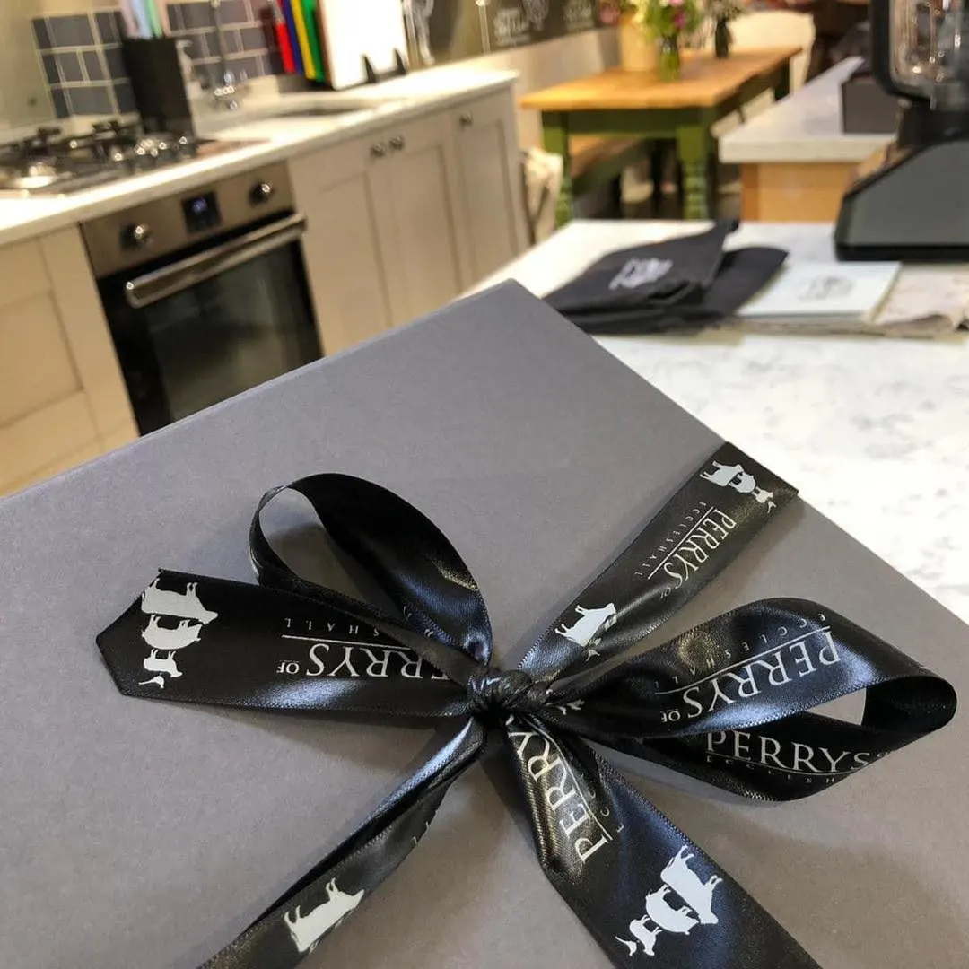 A wrapped gift box with a black ribbon bow sits on a kitchen counter.