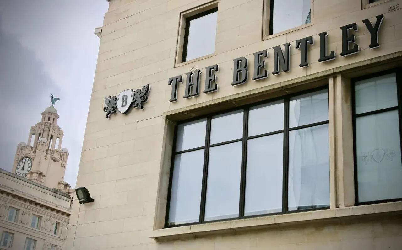 Exterior of The Bentley building with signage, historic architecture and clock tower visible in background.