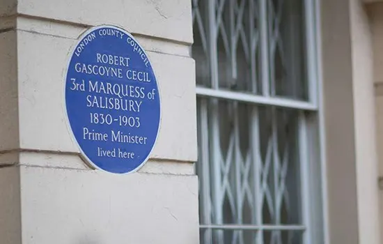 Blue heritage plaque on white building wall commemorating Robert Gascoyne Cecil, 3rd Marquess of Salisbury.