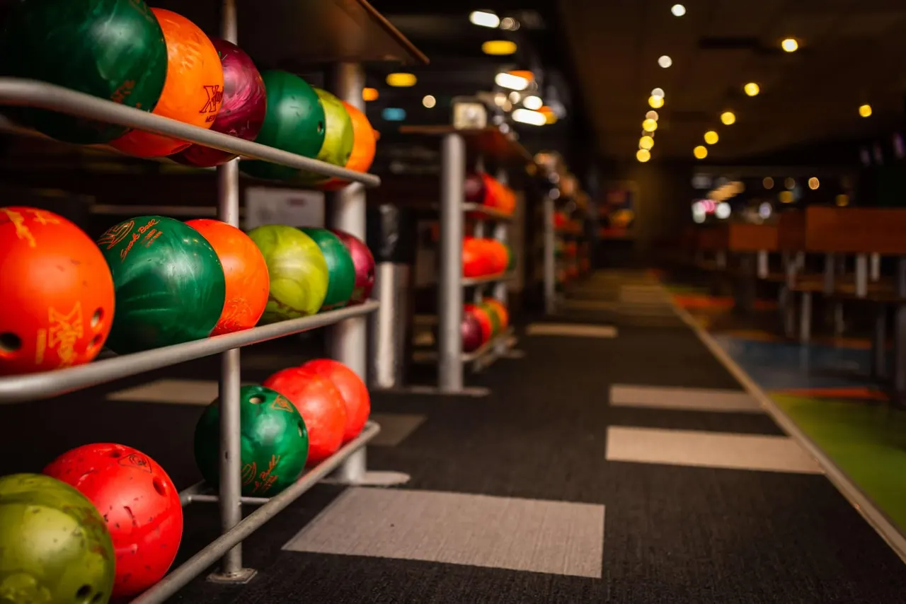 Bright rack of numbered bowling balls at Tenpin