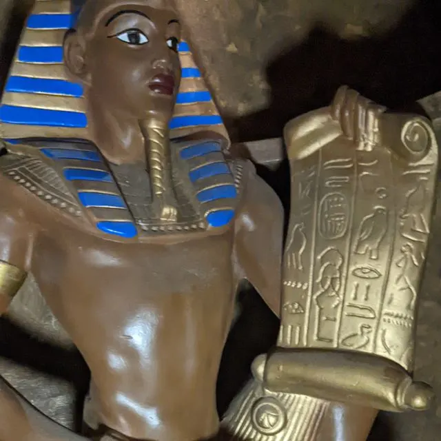 Close-up of Egyptian-themed decorative statues and figurines with gold and blue detailing.