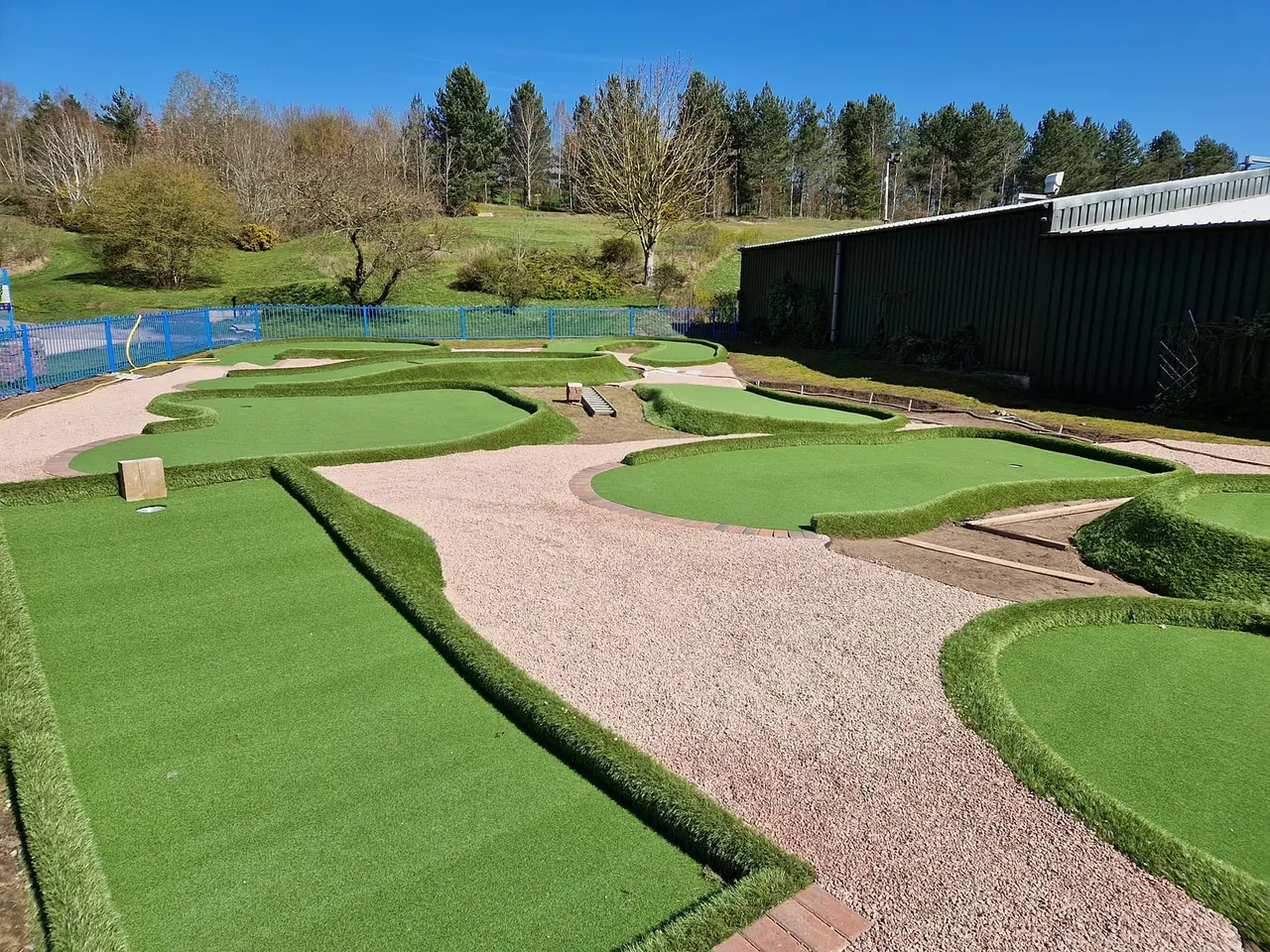 Mini golf course overview with putting greens, gravel paths and obstacles