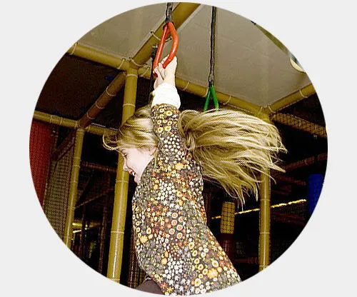 Decorative rooster figure covered in sequins and glitter hanging inside play area.