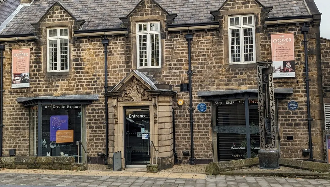 Victorian stone building facade with shop and gallery frontage displaying entrance and signage.