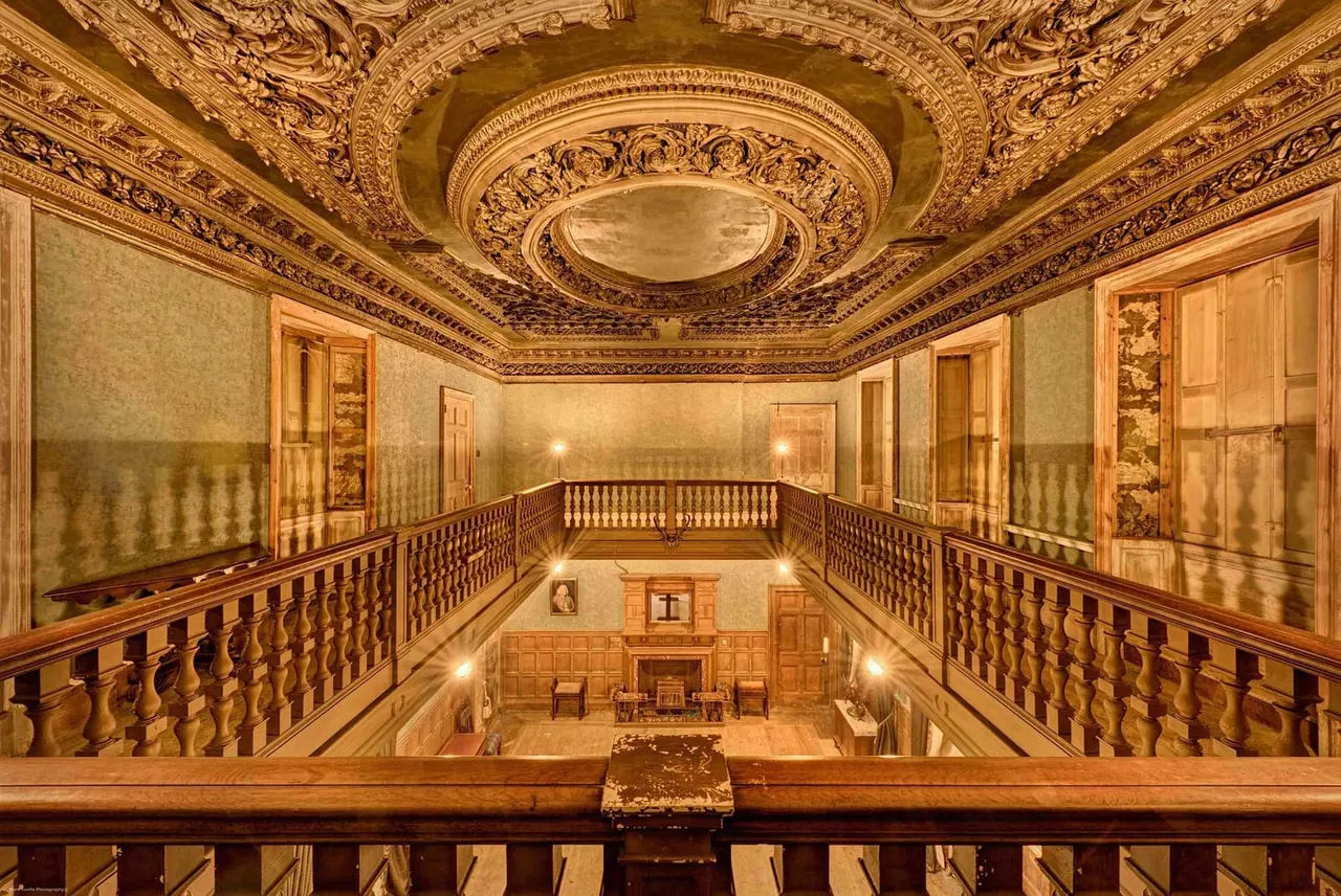 Ornate historic interior with multiple levels of wooden balconies and an elaborate decorated ceiling.