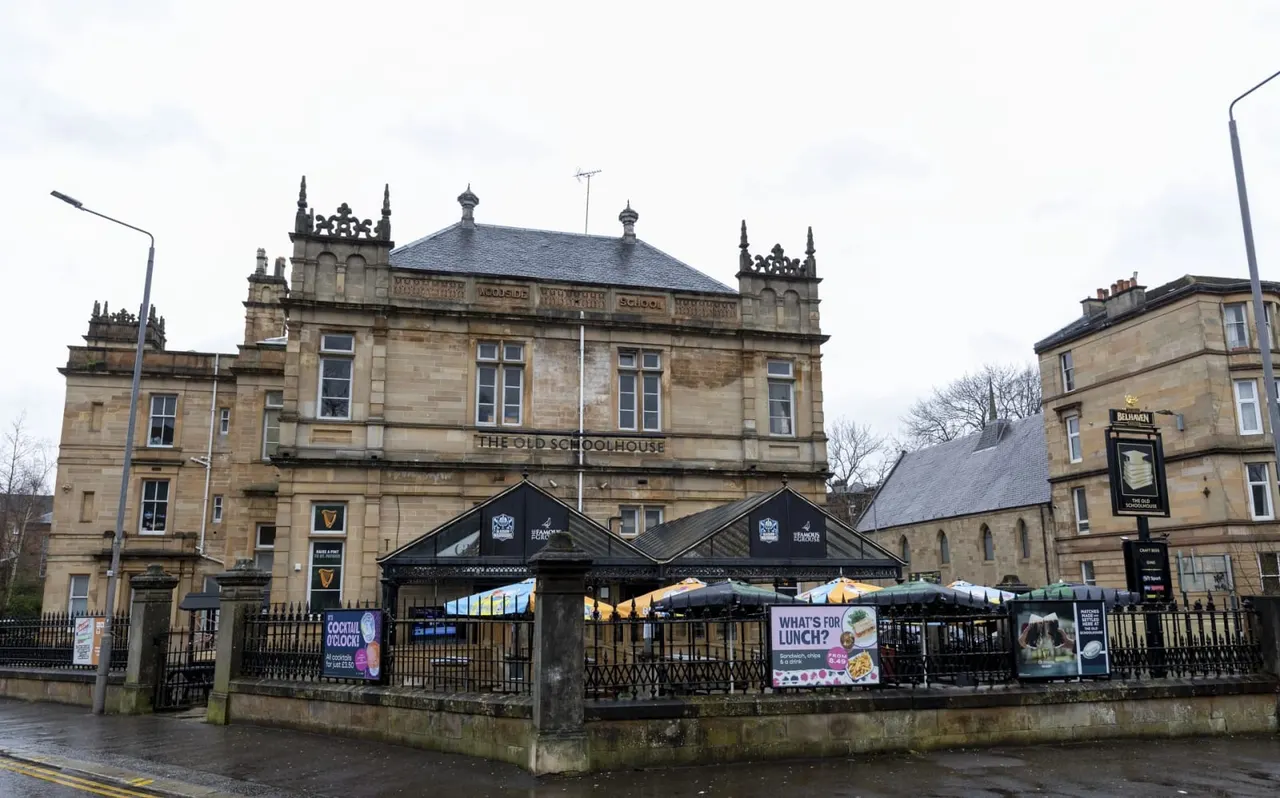 Historic stone building with ornate turrets housing a leisure venue with outdoor seating area and promotional signage.