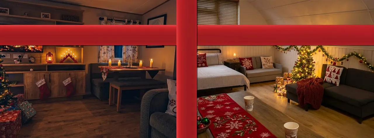 Interior of a glamping lodge decorated for Christmas with beds, seating areas, festive garlands, lit trees and candles.