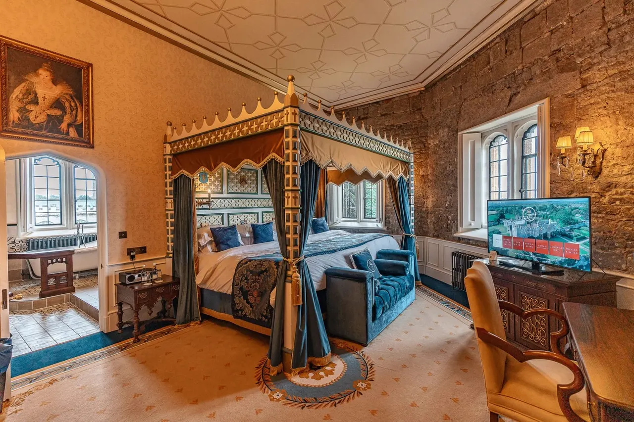 Luxurious four-poster bedroom suite with ornate gold drapes, exposed stone walls, and period furnishings at a castle hotel.