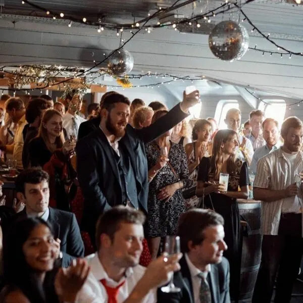 Guests dancing and celebrating in an aircraft cabin decorated with disco balls and fairy lights.
