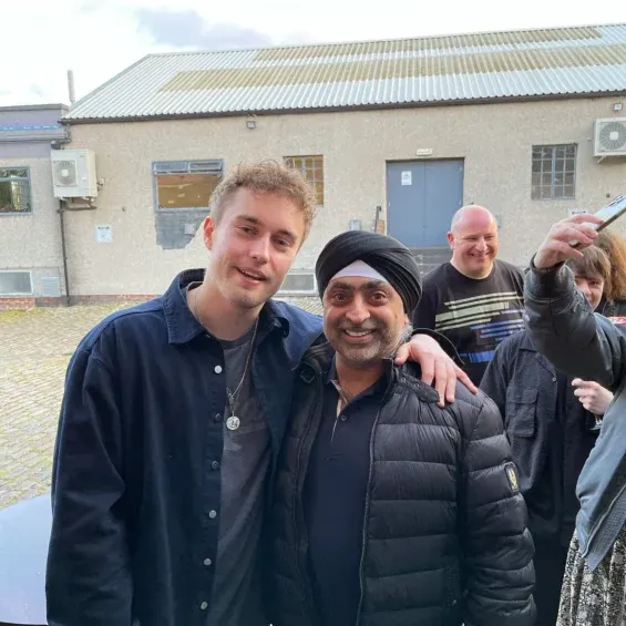 A group of visitors smiling at the camera outside a leisure venue building.