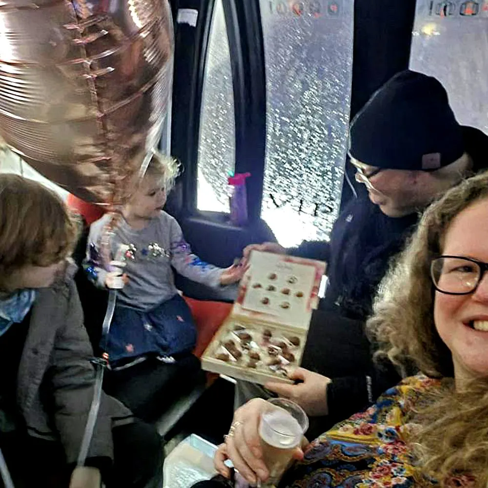 Children and adults inside a viewing capsule examining specimen boxes whilst looking out at the River Mersey below.